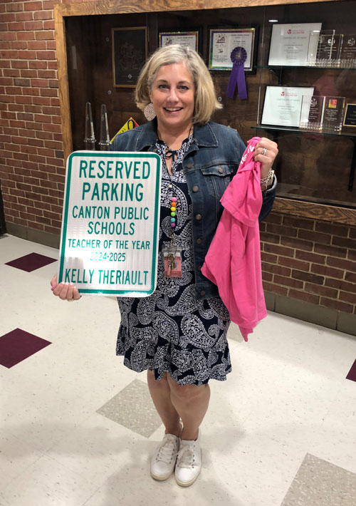 Kelly Theriault holding teacher of the year sign