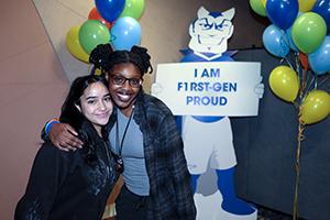 two female students with I am first-gen proud sign