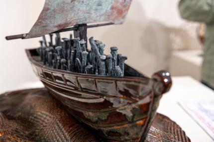  It is a 16-inch-long hand-built ceramic ship, with a square sail made of distressed bronze. Several 250-year-old, blacksmith-crafted nails give the impression of figures on the deck.