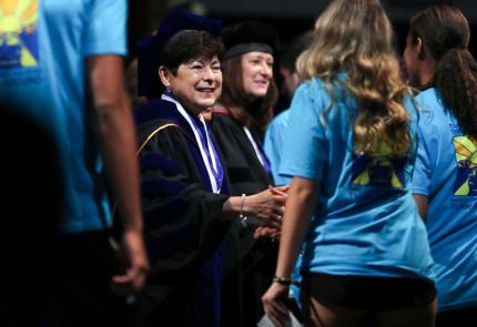 President Toro shakes hands with a student at convocation