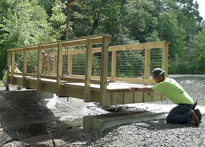 students installing footbridge in local park