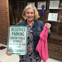 Kelly Theriault holding sign stating that she won teacher of the year