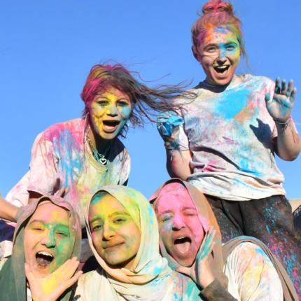 students covered in bright colors from Holi event