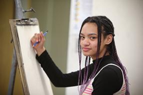 female student about to draw at easel