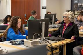 prof. criscola working with student at computer