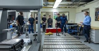 Apprenticeship program students gather in a robotics lab in the Applied Innovation Hub.